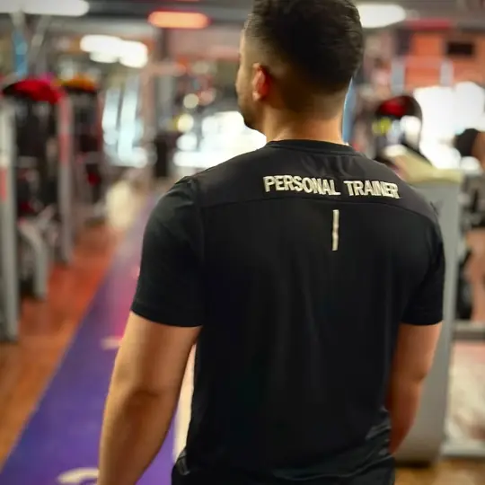 Vitor L. com camiseta de personal trainer na academia